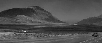 Movie still from “Tetro” (2009), directed by Francis Ford Coppola – A black - and - white photo of a road and a mountain; Extreme Wide shot, Low angle