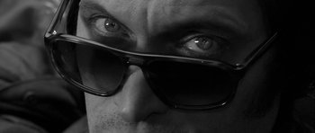 Movie still from “Tetro” (2009), directed by Francis Ford Coppola – A man's face wearing sunglasses; Extreme Close Up shot, Low angle