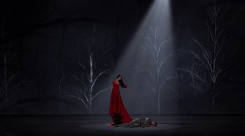 Movie still from “Tetro” (2009), directed by Francis Ford Coppola – A woman in a red dress standing over a man in a gray suit; Extreme Wide shot, Overhead angle