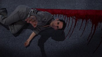 Movie still from “Tetro” (2009), directed by Francis Ford Coppola – A man laying on the ground next to a blood splotches; Medium shot, Overhead angle