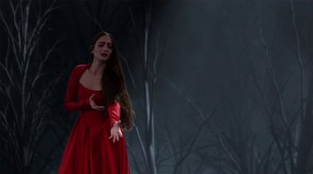 Movie still from “Tetro” (2009), directed by Francis Ford Coppola – A woman in a red dress standing in front of a tree; Medium shot, Over the shoulder angle