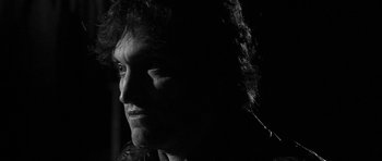 Movie still from “Tetro” (2009), directed by Francis Ford Coppola – A black and white photo of a man's face in the dark; Close Up shot, Low angle