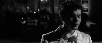 Movie still from “Tetro” (2009), directed by Francis Ford Coppola – A black and white photo of a man wearing a bow tie; Close Up shot, Over the shoulder angle
