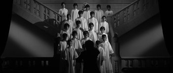 Movie still from “Tetro” (2009), directed by Francis Ford Coppola – A group of young men standing in front of a staircase; Wide shot, High angle