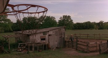 Movie still from “Tex” (1982), directed by Tim Hunter – An old barn with a basketball hoop in the background; Extreme Wide shot, Low angle