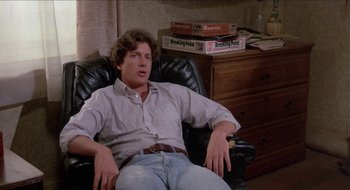 Movie still from “Tex” (1982), directed by Tim Hunter – A man sitting in a chair in front of a desk; Medium shot, Low angle