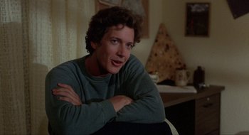 Movie still from “Tex” (1982), directed by Tim Hunter – A man sitting in a chair with his arms crossed; Close Up shot, Over the shoulder angle