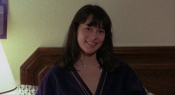 Movie still from “Tex” (1982), directed by Tim Hunter – A woman with long black hair smiles for the camera; Close Up shot, High angle