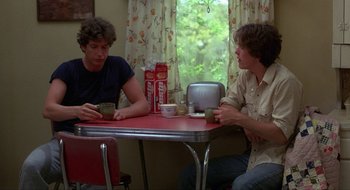Movie still from “Tex” (1982), directed by Tim Hunter – Two men are sitting at a table drinking coffee; Medium shot, Over the shoulder angle