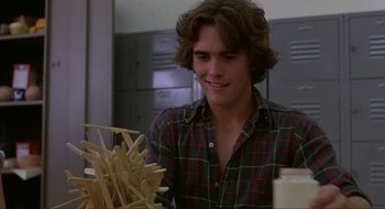 Movie still from “Tex” (1982), directed by Tim Hunter – A man sitting in front of a pile of fries; Close Up shot, Over the shoulder angle