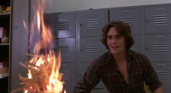 Movie still from “Tex” (1982), directed by Tim Hunter – A man sitting in front of a fire in a room; Medium shot, Over the shoulder angle