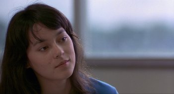 Movie still from “Tex” (1982), directed by Tim Hunter – A woman sitting in front of a window looking to her left; Close Up shot, Over the shoulder angle