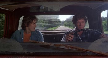 Movie still from “Tex” (1982), directed by Tim Hunter – A man and a woman sitting in the back of a car; Medium shot, Over the shoulder angle