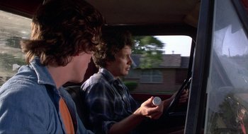 Movie still from “Tex” (1982), directed by Tim Hunter – Two young men in the back seat of a car; Medium shot, Over the shoulder angle