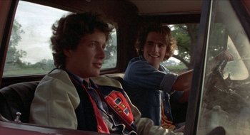 Movie still from “Tex” (1982), directed by Tim Hunter – Two young men sitting in the back seat of a car; Medium shot, Over the shoulder angle