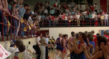 Movie still from “Tex” (1982), directed by Tim Hunter – A group of men standing on top of a basketball court; Extreme Wide shot, High angle