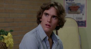 Movie still from “Tex” (1982), directed by Tim Hunter – A young man with long hair and a blue shirt; Close Up shot, Over the shoulder angle