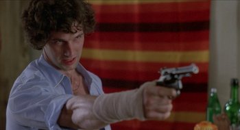 Movie still from “Tex” (1982), directed by Tim Hunter – A man holding a gun in his right hand; Close Up shot, Low angle