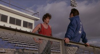 Movie still from “Tex” (1982), directed by Tim Hunter – Two men standing next to each other near a fence; Medium shot, Over the shoulder angle