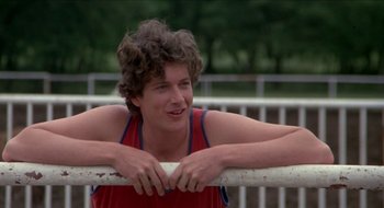 Movie still from “Tex” (1982), directed by Tim Hunter – A young man leaning on a railing in a park; Close Up shot, Low angle