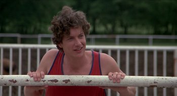 Movie still from “Tex” (1982), directed by Tim Hunter – A young man holding onto a white pole; Close Up shot, Over the shoulder angle