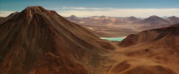 Movie still from “The 33” (2015), directed by Patricia Riggen – A view of a valley with a lake in the middle of it; Extreme Wide shot, High angle
