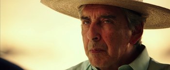 Movie still from “The 33” (2015), directed by Patricia Riggen – An older man wearing a straw hat looking into the distance; Close Up shot, Low angle