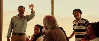 Movie still from “The 33” (2015), directed by Patricia Riggen – A group of people standing next to each other on a field; Medium shot, Over the shoulder angle
