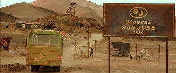 Movie still from “The 33” (2015), directed by Patricia Riggen – A man standing in the middle of a dirt field; Extreme Wide shot, High angle