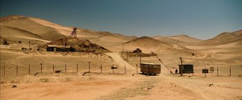 Movie still from “The 33” (2015), directed by Patricia Riggen – An abandoned bus in the middle of a desert landscape; Extreme Wide shot, High angle