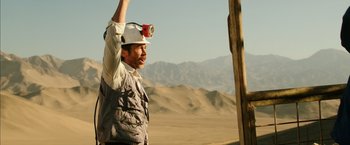 Movie still from “The 33” (2015), directed by Patricia Riggen – A man in a white hard hat holding up a red light; Medium shot, Low angle