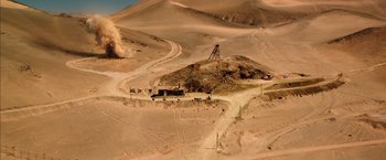 Movie still from “The 33” (2015), directed by Patricia Riggen – An aerial view of a dirt road with a dirt hill in the background; Extreme Wide shot, Overhead angle