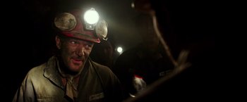 Movie still from “The 33” (2015), directed by Patricia Riggen – A man with a hard hat on in a coal mine; Close Up shot, Over the shoulder angle