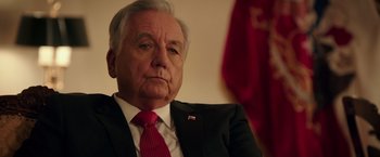Movie still from “The 33” (2015), directed by Patricia Riggen – An older man wearing a suit and red tie; Close Up shot, Low angle