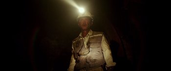 Movie still from “The 33” (2015), directed by Patricia Riggen – A man wearing a hard hat with a light shining on his head; Close Up shot, Low angle