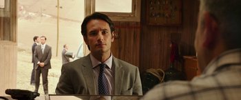 Movie still from “The 33” (2015), directed by Patricia Riggen – A man wearing a suit and tie in front of a mirror; Close Up shot, Over the shoulder angle