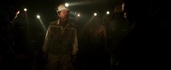 Movie still from “The 33” (2015), directed by Patricia Riggen – A group of men standing next to each other in the dark; Medium shot, High angle