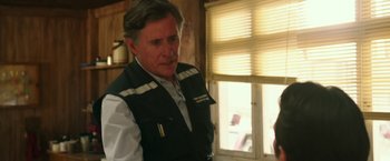 A person wearing a vest near a window