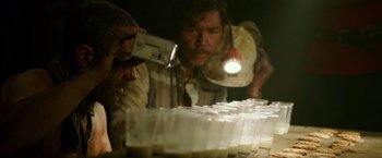 Movie still from “The 33” (2015), directed by Patricia Riggen – A group of people standing next to a row of plastic cups; Close Up shot, High angle