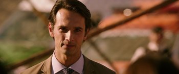 Movie still from “The 33” (2015), directed by Patricia Riggen – A person wearing a suit and tie; Close Up shot, Over the shoulder angle
