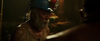 Movie still from “The 33” (2015), directed by Patricia Riggen – An older man wearing a hard hat in a dark room; Close Up shot, High angle