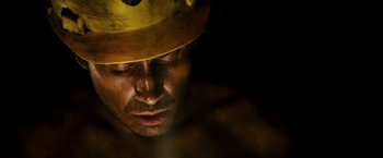 Movie still from “The 33” (2015), directed by Patricia Riggen – A person wearing a hard hat; Close Up shot, Overhead angle