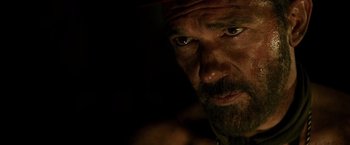 Movie still from “The 33” (2015), directed by Patricia Riggen – A person with a beard and a hat; Close Up shot, Over the shoulder angle