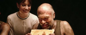 Movie still from “The 33” (2015), directed by Patricia Riggen – A man holding a piece of pie in front of a woman; Close Up shot, Over the shoulder angle