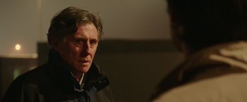 Movie still from “The 33” (2015), directed by Patricia Riggen – A person wearing a jacket near a wall; Close Up shot, Over the shoulder angle