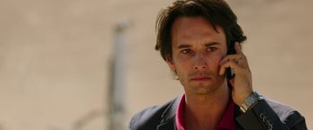 Movie still from “The 33” (2015), directed by Patricia Riggen – A person wearing a suit and tie; Close Up shot, Over the shoulder angle