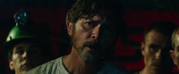 Movie still from “The 33” (2015), directed by Patricia Riggen – A person wearing a white shirt; Close Up shot, Low angle