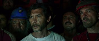 Movie still from “The 33” (2015), directed by Patricia Riggen – A man in a white shirt is looking at the camera; Close Up shot, Low angle