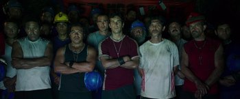 Movie still from “The 33” (2015), directed by Patricia Riggen – A group of men standing next to each other; Medium shot, Low angle