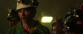 Movie still from “The 33” (2015), directed by Patricia Riggen – A man wearing a hard hat in a building; Close Up shot, Over the shoulder angle